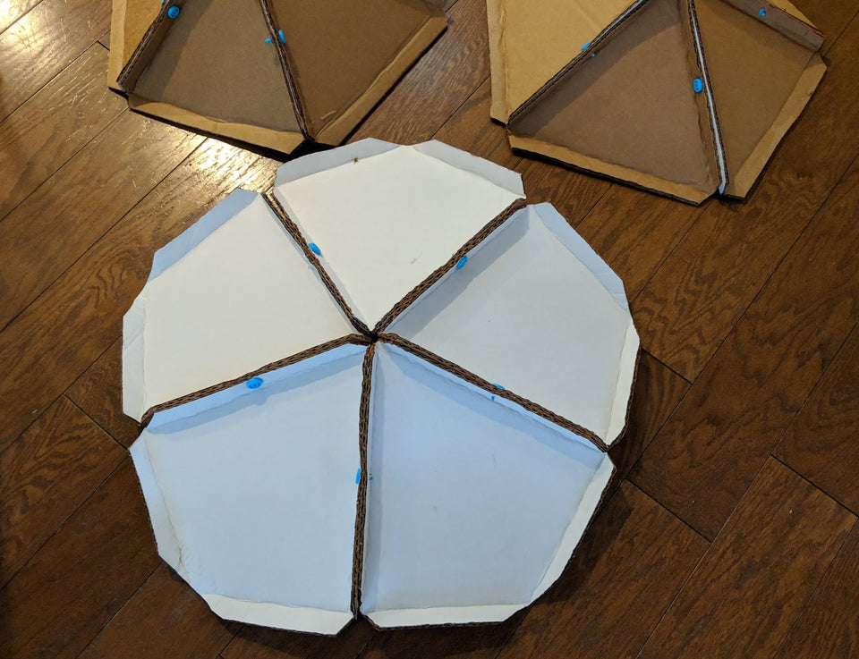 Connecting panels for the cardboard geodesic dome using Makedo cardboard tools.